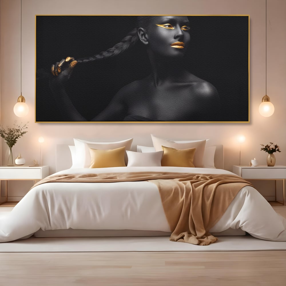 Tablou canvas cu tablou canvas cu femeie vopsita in negru si auriu, in rama de aluminiu auriu, pe perete intr-un dormitor